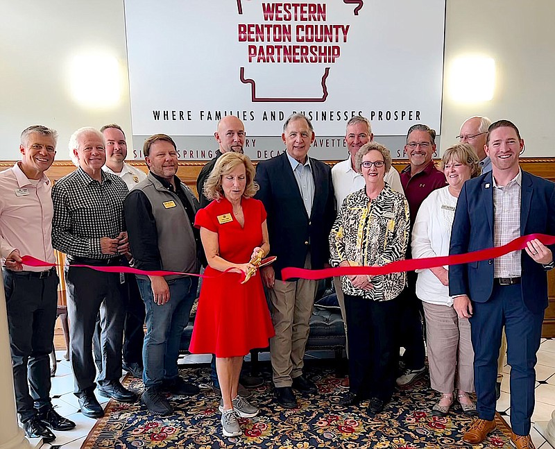 Randy Moll/Westside Eagle Observer
State Rep. Delia Haak (center), joined by local dignitaries and business leaders, cuts the ribbon at the new office of the Western Benton County Partnership in Gentry on Thursday.