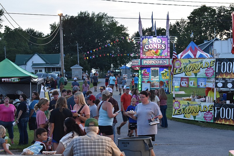 Democrat photo/Garrett Fuller — People visit while others seek out concessions Aug. 7 during the Moniteau County Fair. In addition to carnival rides and events, a wide variety of concession stands were setup at the event offering many different types of food and drink options.