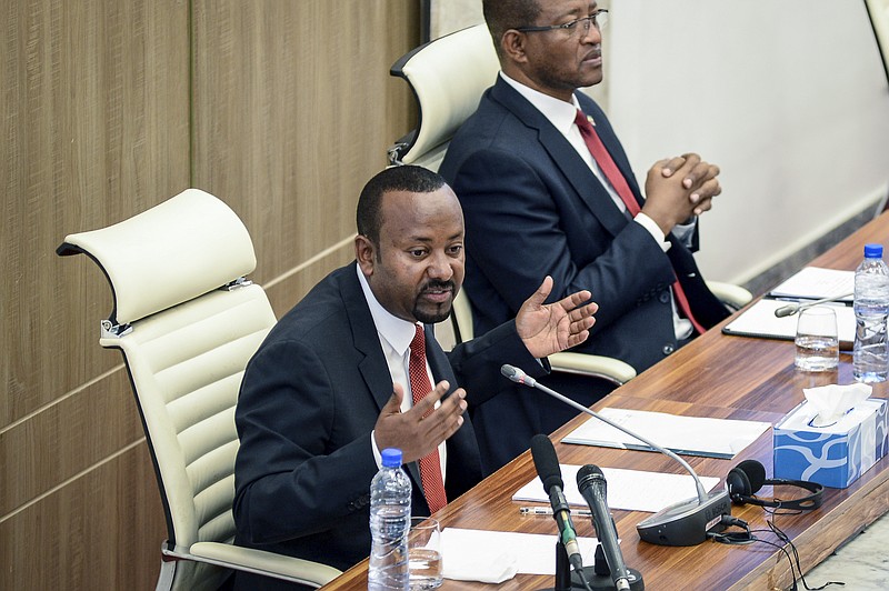FILE - Ethiopia's Prime Minister Abiy Ahmed, left, accompanied by House speaker Tagesse Chafo, right, addresses the parliament in the capital Addis Ababa, Ethiopia on Nov. 15, 2022. Authorities in Ethiopia are carrying out mass arrests of hundreds, even thousands, of people in the capital after deadly unrest in the countrys Amhara region, lawyers and witnesses said. Ethiopias parliament is to vote Monday Aug. 14, 2023 on giving formal approval to extraordinary measures which allow authorities to arrest suspects without a warrant, conduct searches and impose curfews. (AP Photo/File)