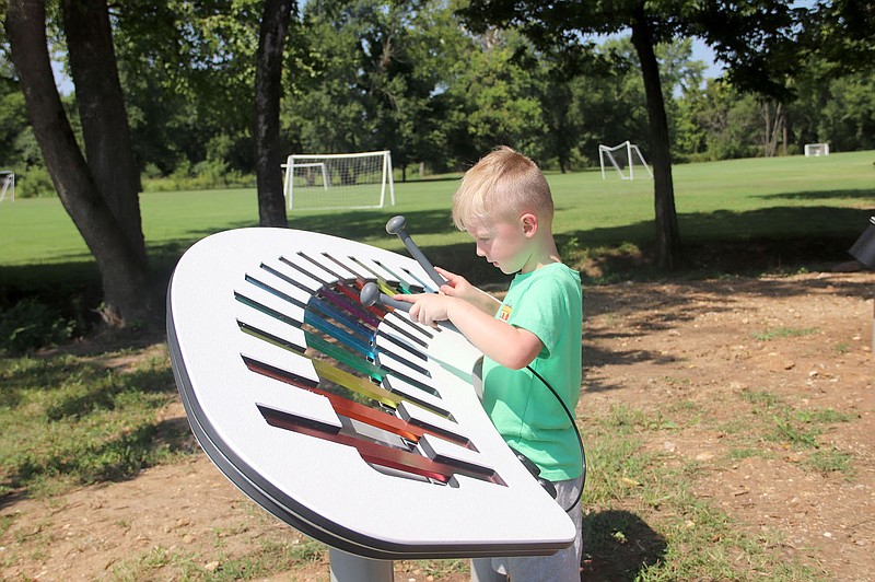 Lynn Kutter/Enterprise-Leader 
Barrett Kirkendall of Fayetteville plays the large xylophone at the new playground at Muddy Fork Park in Prairie Grove.