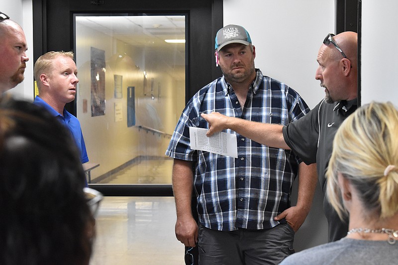 Democrat photo/Garrett Fuller — California R-I Assistant Superintendent Matt Abernathy, right, discusses the new secure-entry vestibule Aug. 16 at the elementary school during the Board of Education's tour throughout district facilities. Instead of utilizing the original main entrance, elementary school visitors will now enter through the vestibule, located to the right of the main entrance. The vestibule enhances security at the school by limiting guests' access to the rest of the building.