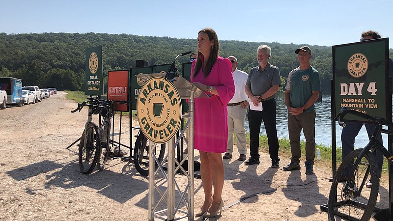 Gov. Sarah Huckabee Sanders (center) announces the inaugural Arkansas Graveler bicycle ride event on Thursday, Aug. 24, 2023, at Lake Wilson in Fayetteville. The event will happen in June 2024 and span more than 300 miles between Fayetteville and Jonesboro. (NWA Democrat-Gazette/Stacy Ryburn)