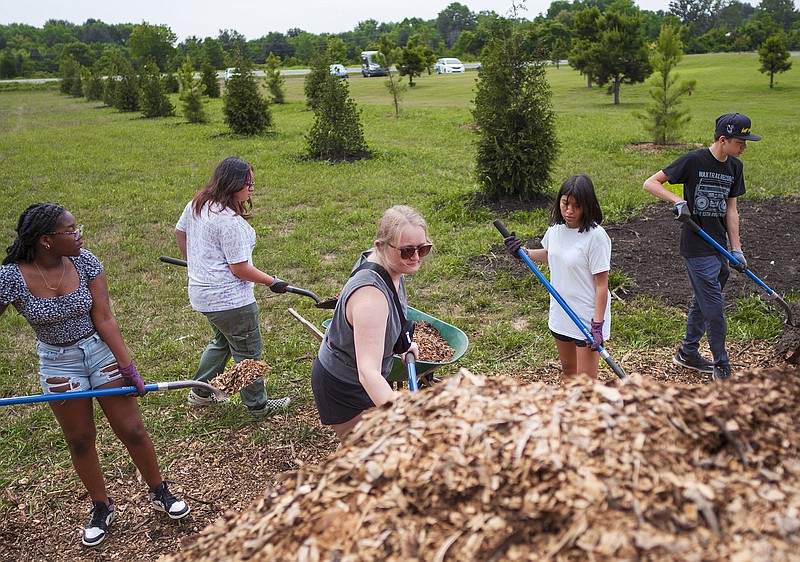 Chantilir McCorvy (from left), Dalilah Zalzana, Emma Lauth, Lizette Flores-Morales and Kai Logan shovel mulch, Monday, June 27, 2023 at the new Samaritan Community Center Farm in Rogers. The Teen Action Support Center volunteered their time to help prune tomatoes, mulch pathways and weed during a community service day.
(NWA Democrat-Gazette/Charlie Kaijo)