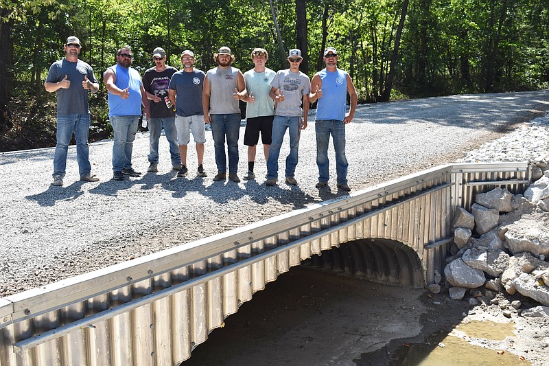 Democrat photo/Garrett Fuller — Drinkard Construction Get It, LLC, crew members pose atop a culvert Aug. 30, 2023, which they constructed on Old Swiss Road near Kratzer Road north of California, Missouri. Pictured, from left, are: Corey Gagnon, Josh Hoskins (co-owner of Drinkard Construction Get It, LLC), Justin Runkle, Rick Mettle, Hayden Furcinite, Preston Miller, Jakub Barnes and Curt Drinkard (co-owner of Drinkard Construction Get It, LLC).