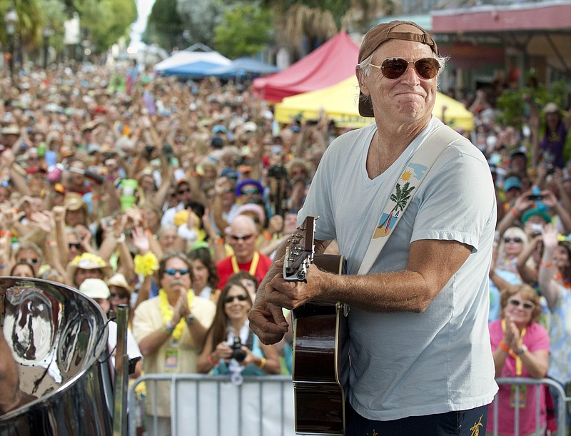 FILE- In this Nov. 4, 2011, file photo released by the Florida Keys News Bureau, singer/songwriter Jimmy Buffett performs before fans on Duval Street in Key West, Fla.  Buffett, who popularized beach bum soft rock with the escapist Caribbean-flavored song “Margaritaville” and turned that celebration of loafing into an empire of restaurants, resorts and frozen concoctions, has died, Friday, Sept. 1, 2023.  (Rob O'Neal/Florida Keys News Bureau via AP)