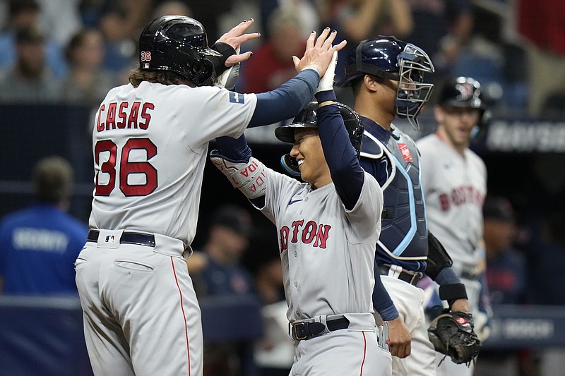 Boston Red Sox's Masataka Yoshida, center, of Japan, celebrates with Triston Casas, left, after Yoshida hit a two-run home run off Tampa Bay Rays relief pitcher Andrew Kittredge during the eighth inning of a baseball game Monday, Sept. 4, 2023, in St. Petersburg, Fla. Catching for Tampa Bay is Christian Bethancourt. (AP Photo/Chris O'Meara)