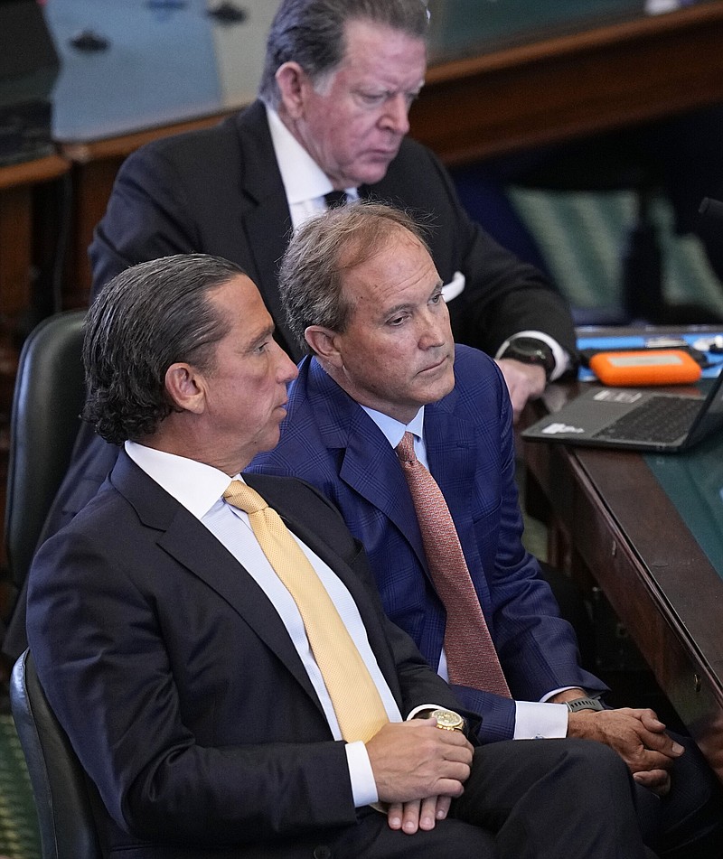 Texas state Attorney General Ken Paxton, center, sits with his attorneys Dan Cogdell, rear, and Tony Buzbee, front, during the his impeachment trial in the Senate Chamber at the Texas Capitol, Tuesday, Sept. 5, 2023, in Austin, Texas. (AP Photo/Eric Gay)