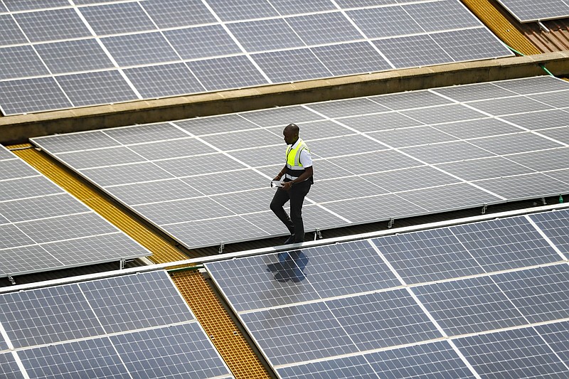Mark Munyua, CP solar's technician, examines solar panels on the roof of a company in Nairobi, Kenya, Friday, Sept. 1, 2023. Access to electricity remains a major challenge for over half a billion people in sub-Saharan Africa, and power outages are common. In South Africa and Kenya, solar is being used to power major businesses. (AP Photo/Brian Inganga)