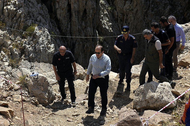 Turkish governor of Mersin, Ali Hamza Pehlivan, front center, during his visit to the Morca cave during a rescue operation near Anamur, south Turkey, Saturday, Sept. 9, 2023. American researcher Mark Dickey, 40, who fell ill almost 1,000 meters (more than 3,000 feet) below the entrance of a cave in Turkey, has recovered sufficiently enough to be extracted in an operation that could last three or four days, a Turkish official was quoted as saying on Friday. (AP Photo/Khalil Hamra)
