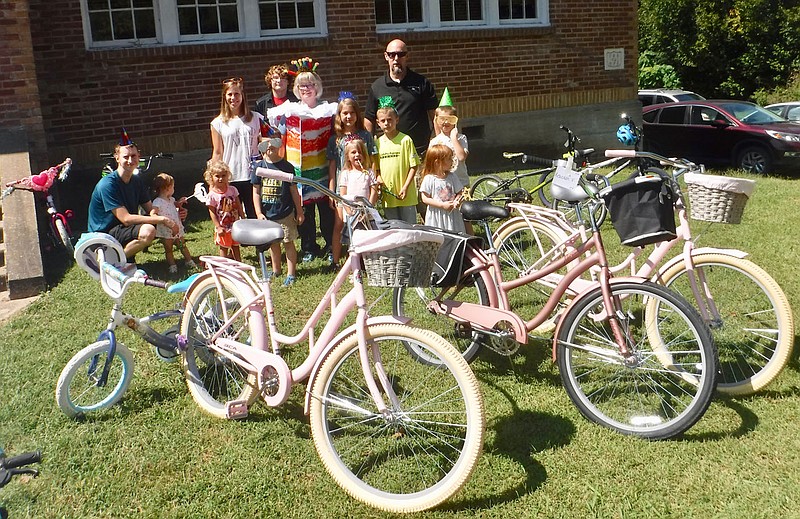 Susan Holland/Westside Eagle Observer
Shane Weber (right rear), mayor of Sulphur Springs, poses with Renee Wall (in costume), librarian at Gamble Elementary School in Centerton, and several young library patrons with some of the bicycles given away at the Sulphur Library birthday celebration Saturday, Sept. 9. Bicycles were donated by Pedal It Forward in Bentonville/Bella Vista.
