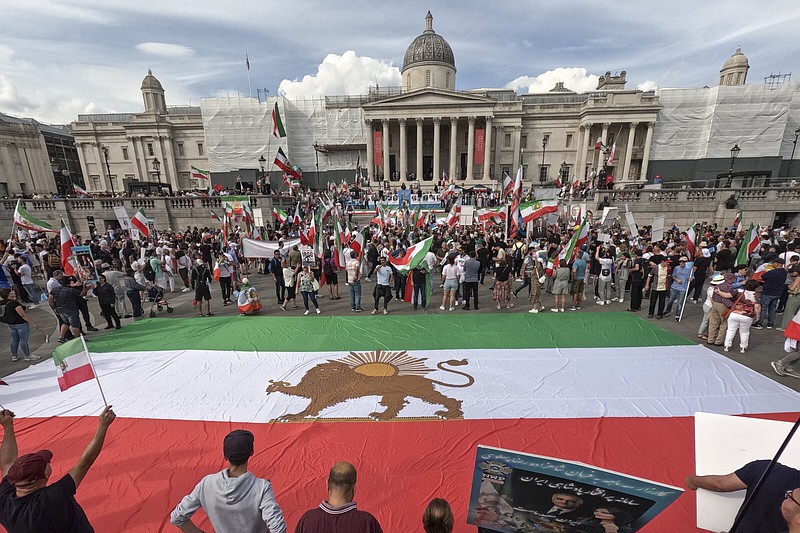 Demonstrators display a giant pre-revolution Iran flag as they gather in Trafalgar Square, in London, Saturday, Sept. 16, 2023, as today marks the anniversary of the death of Mahsa Amini in Iran. (AP Photo/Alberto Pezzali)