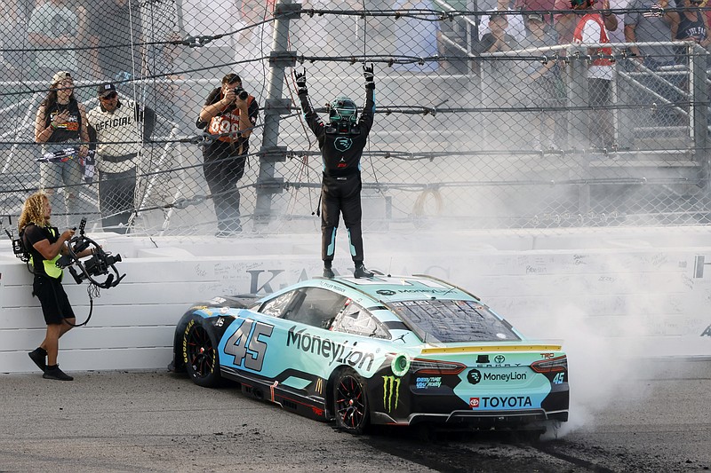 Tyler Reddick, center, celebrates on the track after winning a NASCAR Cup Series auto race at Kansas Speedway in Kansas City, Kan., Sunday, Sept. 10, 2023. (AP Photo/Colin E. Braley)