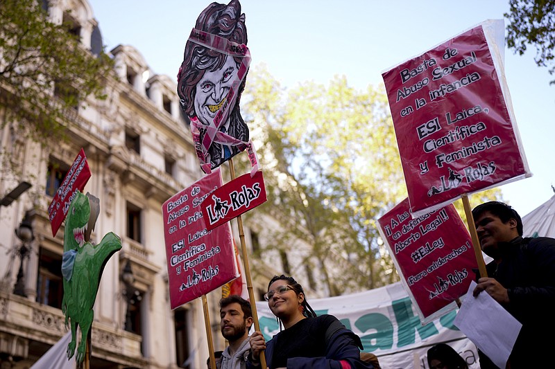 Una mujer con un poster con la imagen del aspirante presidencial Javier Milei rodeado por una cinta de peligro, antes del inicio de la marcha por el Día Internacional del Aborto Seguro en Buenos Aires, Argentina, el jueves 28 de septiembre de 2023. (AP Foto/Natacha Pisarenko)