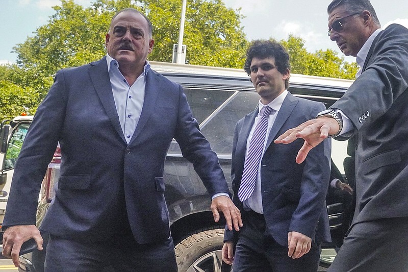 File - Sam Bankman-Fried, center, arrives at Manhattan federal court on Aug. 11, 2023, in New York. The fraud trial of Bankman-Fried, the founder of failed cryptocurrency brokerage FTX, begins Tuesday with jury selection. (AP Photo/Bebeto Matthews, File)