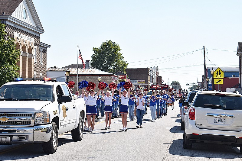 Democrat photo/Garrett Fuller — California High School cheerleaders and the Pinto Pride marching band follow School Resource Officer Scott Harkins' truck Friday during the Homecoming parade route down North Oak Street.