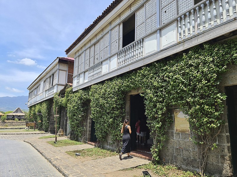 This image provided by the Philippine Department of Tourism shows Shaina Renee Manlangit entering the historic resort, Las Casas Filipinas de Acuzar, in Bagac, Bataan in the Philippines March 2023. The Philippines has long been interested in attracting Filipinos in the U.S. to come and add to the economy, but its incentives have mostly drawn retirees or immigrants catching up with relatives. Today, they are honing in on young Filipino American professionals who live on TikTok and Instagram. (Philippine Department of Tourism via AP)
