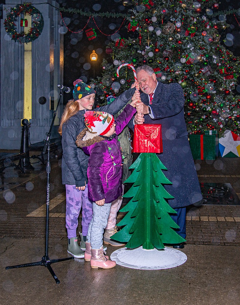 Ken Barnes/News Tribune
Mayor Ron Fitzwater and his granddaughters moves the switch to light the Mayor's Christmas Tree on a rainy Thursday night at Rotary Centennial Park.