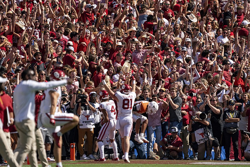 Oklahoma fans celebrate the game-winning touchdown reception by wide receiver Nic Anderson (4) during the second half of an NCAA college football game at the Cotton Bowl, Saturday, Oct. 7, 2023, in Dallas. Oklahoma won 34-30. (AP Photo/Jeffrey McWhorter)