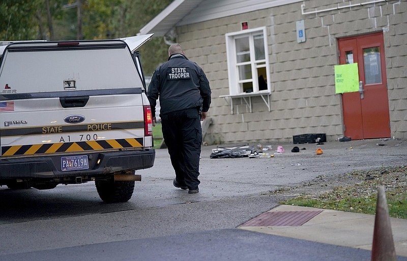 A trooper from the Pennsylvania State Police Reconstruction Unit works at the crime scene of a fatal shooting at the Chevy Chase Community Center, Sunday, Oct. 8, 2023, in White Township, Indiana County, Pa. State police in Indiana County said troopers, local officers and emergency services responded at 12:35 a.m. Sunday to the shooting at the center in White Township, about 50 miles (80 kilometers) northeast of Pittsburgh. (Sean Stipp/TribLIVE.com via AP)