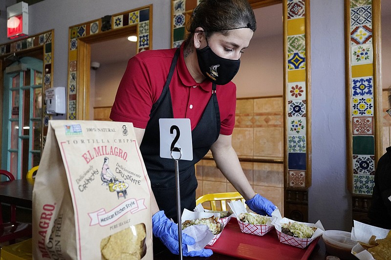 A waitress works at a restaurant in Chicago, Thursday, March 23, 2023. (AP Photo/Nam Y. Huh)