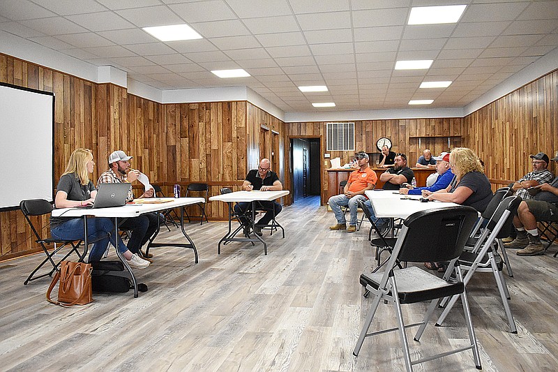 Democrat photo/Garrett Fuller — Moniteau County northern commissioner Clint Hoellering, second from left, asks a contractor a question Thursday afternoon during the bid opening for the Moniteau County Sheriff's Office building project in the old VFW hall at 208 E. North St. Kusgen Construction, of California, had the lowest bid with a base bid of $1,995,412. They also had the shortest timeframe, with a 240 day estimate for the project duration.