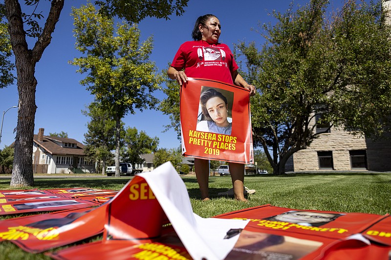 Melissa Lonebear holds a banner with a picture of Kaysera Stops Pretty Places on it during a rally in support of the Missing and Murdered Indigenous People movement at the Big Horn County Building on Tuesday, Aug. 29, 2023, in Hardin, Mont. (AP Photo/Mike Clark)