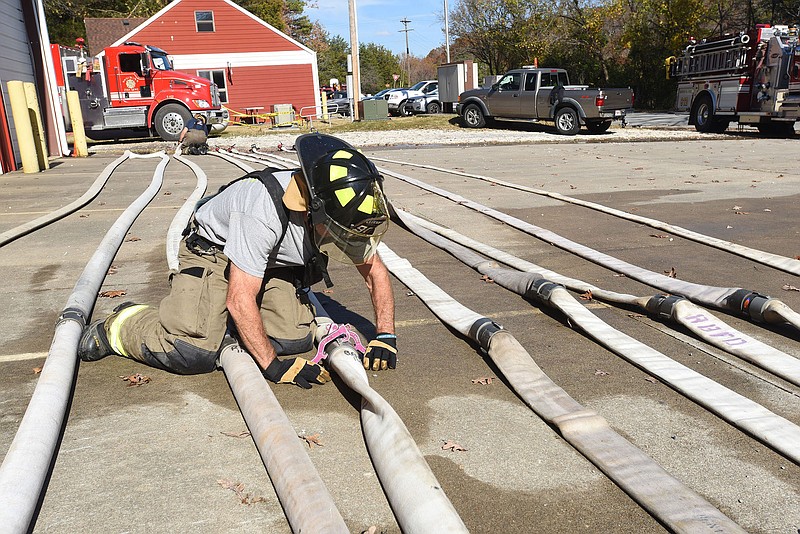 Cecil McLeroy, a firefighter with Rocky Branch Volunteer Fire Department, uncouples fire hoses Nov. 2 after they were pressure-tested during annual hose testing at the department in east Benton County near Beaver Lake.
(File Photo/NWA Democrat-Gazette/Flip Putthoff)