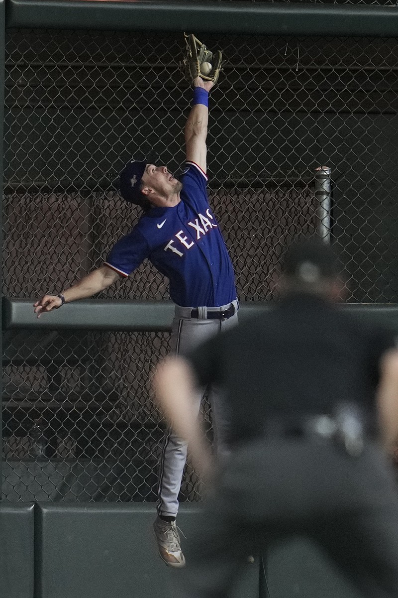 Texas Rangers' Evan Carter catches a ball at the wall hit by Houston Astros' Alex Bregman during the eighth inning of Game 1 of the baseball AL Championship Series Sunday, Oct. 15, 2023, in Houston. (AP Photo/Godofredo A. Vasquez)