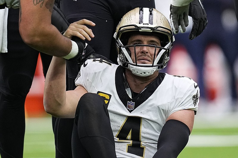 New Orleans Saints quarterback Derek Carr (4) is helped by center Erik McCoy after being sacked in the second half of an NFL football game against the Houston Texans in Houston, Sunday, Oct. 15, 2023. (AP Photo/Eric Gay)