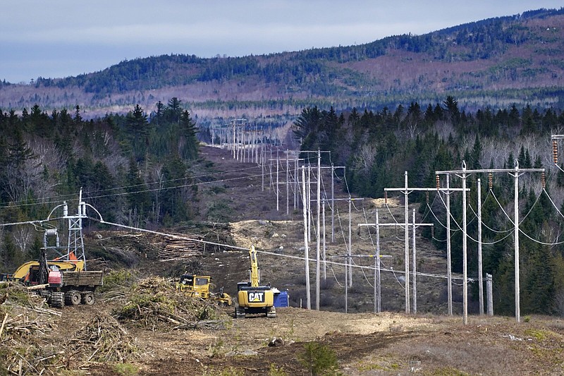 FILE - Heavy machinery is used to cut trees to widen an existing Central Maine Power power line corridor to make way for new utility poles, April 26, 2021, near Bingham, Maine. Stalled spending on electrical grids worldwide is slowing the rollout of renewable energy and could put efforts to limit climate change at risk if millions of miles of power lines aren't added or refurbished in the next few years. The International Energy Agency said in a report Tuesday that the capacity to connect to and transmit electricity isn't keeping pace with the rapid growth of clean energy technology like solar and wind power, electric cars and heat pumps. (AP Photo/Robert F. Bukaty, File)