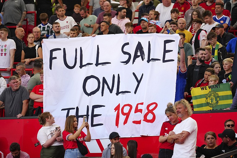Seguidores del Manchester United develan una pancarta que pide la venta completa del equipo antes del encuentro ante Brentford el sábado 7 de octubre del 2023. (AP Foto/Jon Super)
