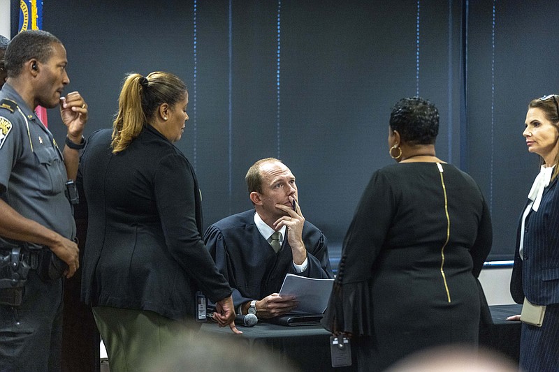 Fulton Superior Court Judge Scott McAfee, center, receives information during jury selection for lawyer Kenneth Chesebro's trial, Friday, Oct. 20, 2023, at the Fulton County Courthouse in Atlanta. Jury selection began Friday for Chesebro, the first defendant to go to trial in the Georgia case that accuses former President Donald Trump and others of illegally scheming to overturn the 2020 election in the state. (Alyssa Pointer/Pool Photo via AP)