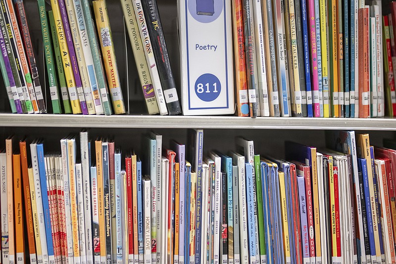 FILE - Books sit on shelves in an elementary school library in suburban Atlanta, on Friday, Aug. 18, 2023. The battle over how to teach reading has landed in court. With momentum shifting in favor of research-backed strategies known as the “science of reading,” states and some school districts have been ditching once popular programs amid concerns that they arent effective. (AP Photo/Hakim Wright Sr., File)