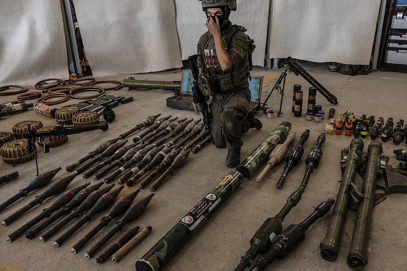 An Israeli officer, identified as Major G. under briefing ground rules, shows a cache of confiscated Hamas weapons at a military base Oct. 20, 2023, in southern Israel. (Heidi Levine for The Washington Post)