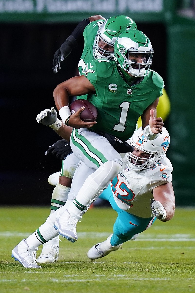 Philadelphia Eagles quarterback Jalen Hurts (1) scrambles to pass under pressure from Miami Dolphins defensive tackle Zach Sieler during the second half of an NFL football game Sunday, Oct. 22, 2023, in Philadelphia. (AP Photo/Chris Szagola)