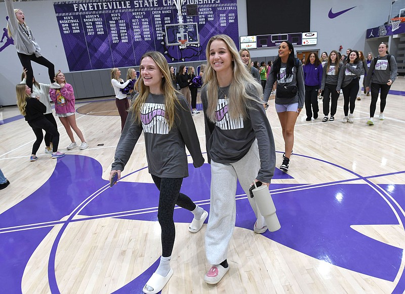 Madison Williams (left) and Alex Beavers, both members of the Fayetteville High School volleyball team, smile Friday, Oct. 27, 2023, as they lead teammates to a bus waiting outside during a pep rally to celebrate the schools volleyball teams departure from the school to take part in the state championship game. Property values are increasing so rapidly almost all of the taxing entities, including the school districts, are having to roll back their millage rates. Schools are more seriously affected than cities or the county because increased property tax revenue causes a reduction in their state funding. Visit nwaonline.com/photo for today's photo gallery.
(NWA Democrat-Gazette/Andy Shupe)