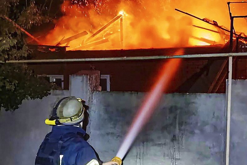 In this photo provided by the Ukrainian Emergency Service, emergency services personnel work to extinguish a fire in Kherson, Ukraine, on Monday, Oct. 30, 2023, following Russian shelling attacks. Russian shells struck residential areas of Ukraine's southern Kherson region, killing a 91-year-old woman in what a local official described Monday as a "terrifying night" in the 20-month war that shows no signs of ending. The overnight shelling set fire to a high-rise apartment building, blew out windows and reduced some apartments to rubble, according to video footage posted by Kherson Gov. Oleksandr Prokudin. (Ukrainian Emergency Service via AP)