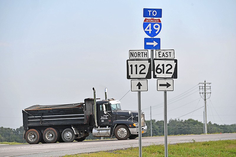 A dump truck heads east Friday, July 28 onto Arkansas 612 at Arkansas 112 north of Elm Springs in Springdale. Regional Planners are pursuing $50 million in federal grants to help pay for two major transportation projects, another section of the Springdale Northern Bypass and improvements to Arkansas 112. Visit nwaonline.com/photo for today's photo gallery. 
(NWA Democrat-Gazette/Andy Shupe)