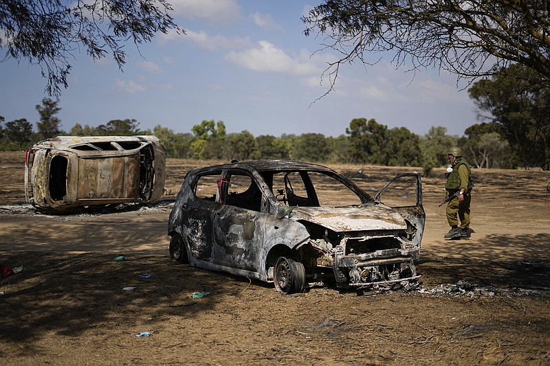 FILE - Israeli soldiers inspect the site of a music festival near the border with the Gaza Strip in southern Israel, Friday. Oct. 13, 2023.  Body camera footage has emerged, Saturday, Nov. 4,  showing Israeli security forces searching for survivors in the aftermath of the bloody Hamas rampage through an outdoor music concert in southern Israel.  (AP Photo/Ariel Schalit, File)