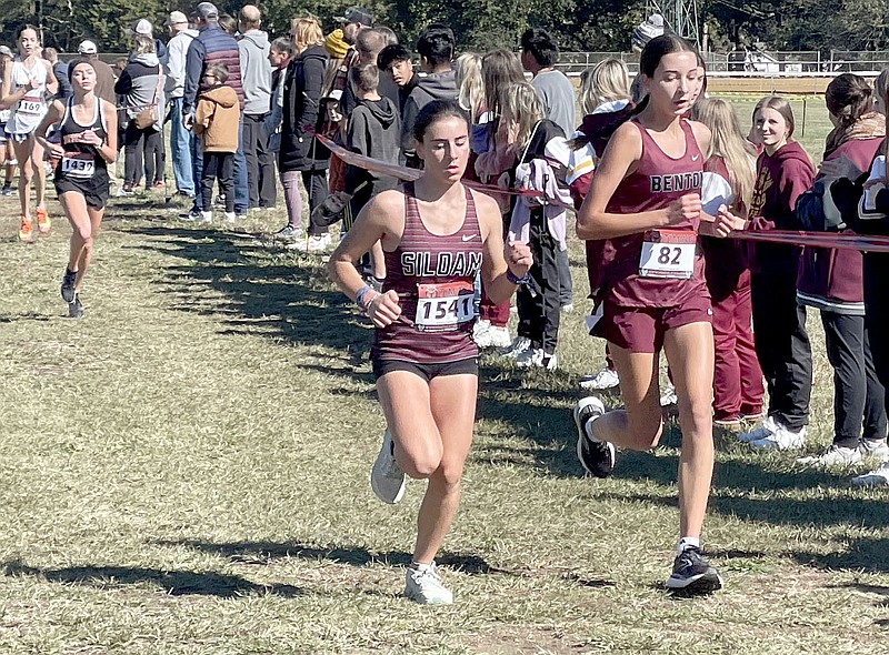 Henry Apple/NWA Democrat-Gazette 
Siloam Springs freshman Amelie Seauve (middle) runs beside Bentons Madeline Moran during the Class 5A state cross country meet on Thursday at Oaklawn Park in Hot Springs. Seauve finished 17th overall in the meet.