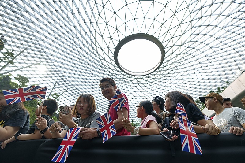 Singaporean hold British flags as they wait for the arrival of Britain's Prince William at Jewel in Changi airport, Singapore, Sunday, Nov. 5, 2023. (AP Photo/Vincent Thian)