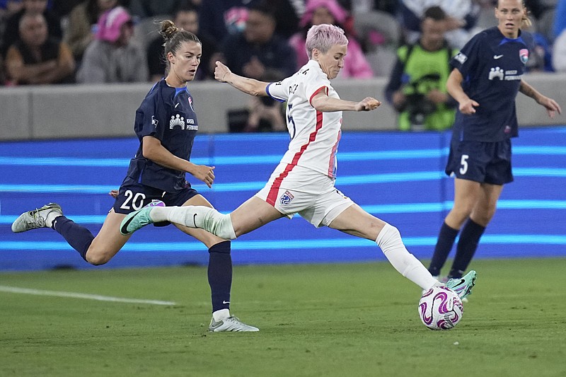 OL Reign forward Megan Rapinoe, center, passes the ball as San Diego Wave defender Christen Westphal defends Sunday in San Diego. (AP Photo/Gregory Bull)