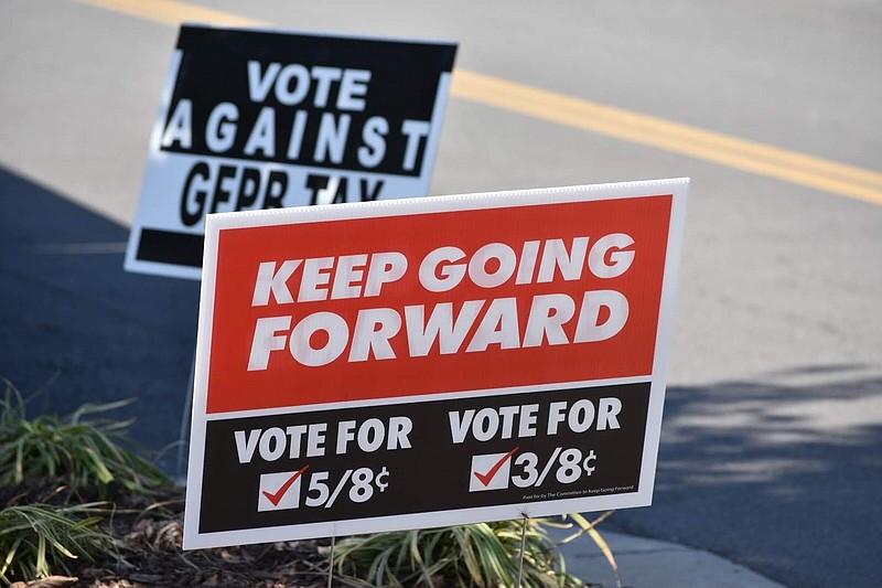 A campaign sign urging Pine Bluff voters to approve five-eighths-cent and three-eighths-cent sales taxes is propped in front of a sign opposing the taxes outside the Jefferson County Courthouse on Tuesday. (Pine Bluff Commercial/I.C. Murrell)