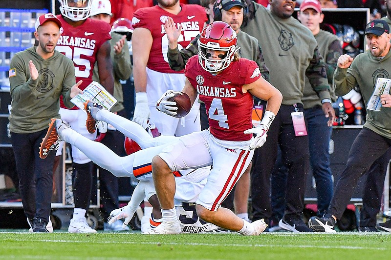 Arkansas wide receiver Isaac TeSlaa (4) runs after a catch as Auburn safety Jaylin Simpson (36) defends Saturday during the second quarter of the Razorbacks 48-10 loss to the Tigers at Donald W. Reynolds Razorback Stadium in Fayetteville. (NWA Democrat-Gazette/Hank Layton)
