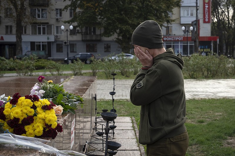 A servicewomen cries as she lays flowers to commemorate those killed in the war, as the city marks one year since Ukraine retook the city of Kherson from occupying Russian forces in Kherson, Ukraine, Saturday, Nov. 11, 2023.  (AP Photo/Efrem Lukatsky)