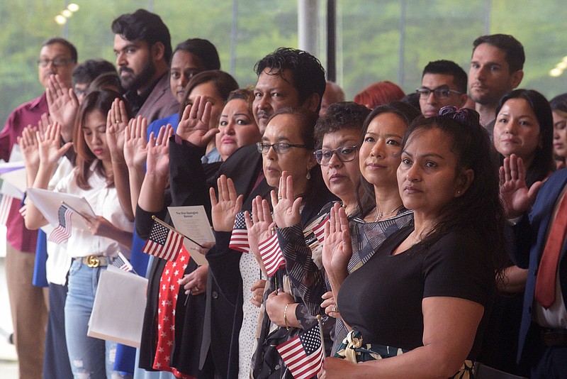 New citizens of the United States of America take the Oath of Allegiance on Tuesday Sept. 19 2023 during naturalization proceedings in the Great Hall at Crystal Bridges Museum of American Art in Bentonville.  (NWA Democrat-Gazette/Flip Putthoff)