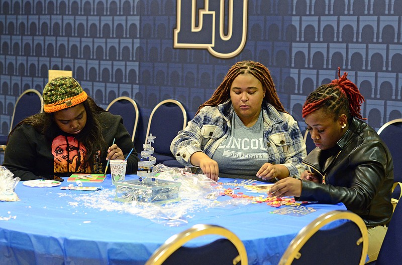 News Tribune file
From left, Lamonica Williams, Jada Johnson and Deonna West paint wooden frames in Christmas colors during last year's Holiday Extravaganza hosted by Lincoln University.
