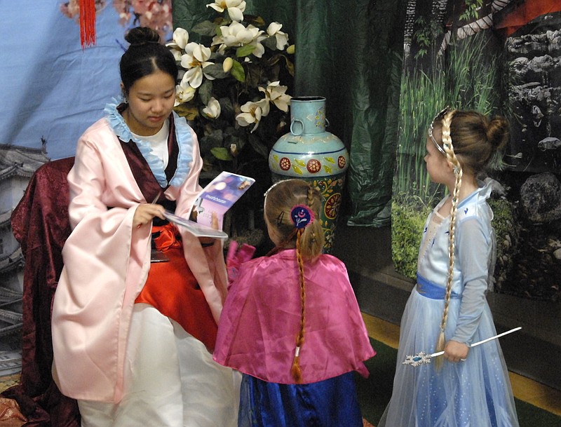 Miriam Bazylewicz/News Tribune photo: 
Zoe Cheng, dressed as Mulan, signs autographs for Lainey Swope, 3, left, and Olivia Swope, 5, on Saturday morning, Nov. 18, 2023, at First United Methodist Church in the annual Princess Party to benefit Little Explorers Discovery Center.