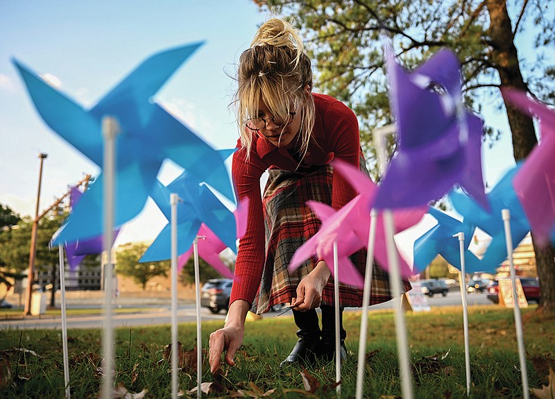 Al Allen arranges pinwheels, representing the 141,000 kids who have lost Medicaid coverage since April, in the shape of the state as she helps prepare for a vigil near the Arkansas State Capitol on Tuesday, Nov. 21, 2023. The vigil was held by Arkansas Community Organizations to demand that the Arkansas Department of Human Services (DHS) restore health coverage to households who may be still eligible for Medicaid.

(Arkansas Democrat-Gazette/Stephen Swofford)