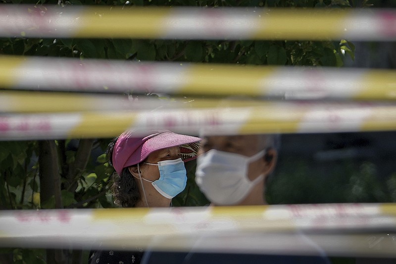 AP file
Residents wearing face masks line up behind barricaded tapes for COVID mass testing May 15, 2022, in Beijing. The World Health Organization says its made an official request to China for information about a potentially worrying spike in respiratory illnesses and clusters of pneumonia in children.